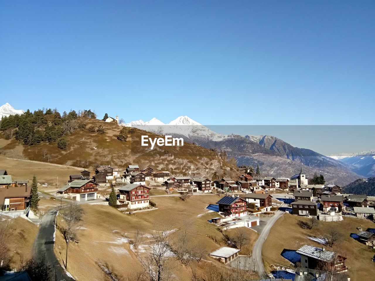 Scenic view of townscape against clear blue sky