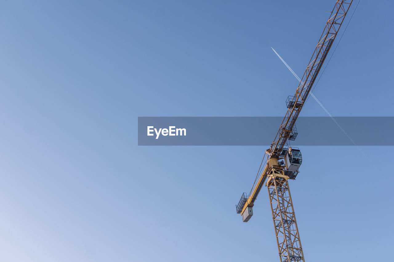 Low angle view of crane against clear sky