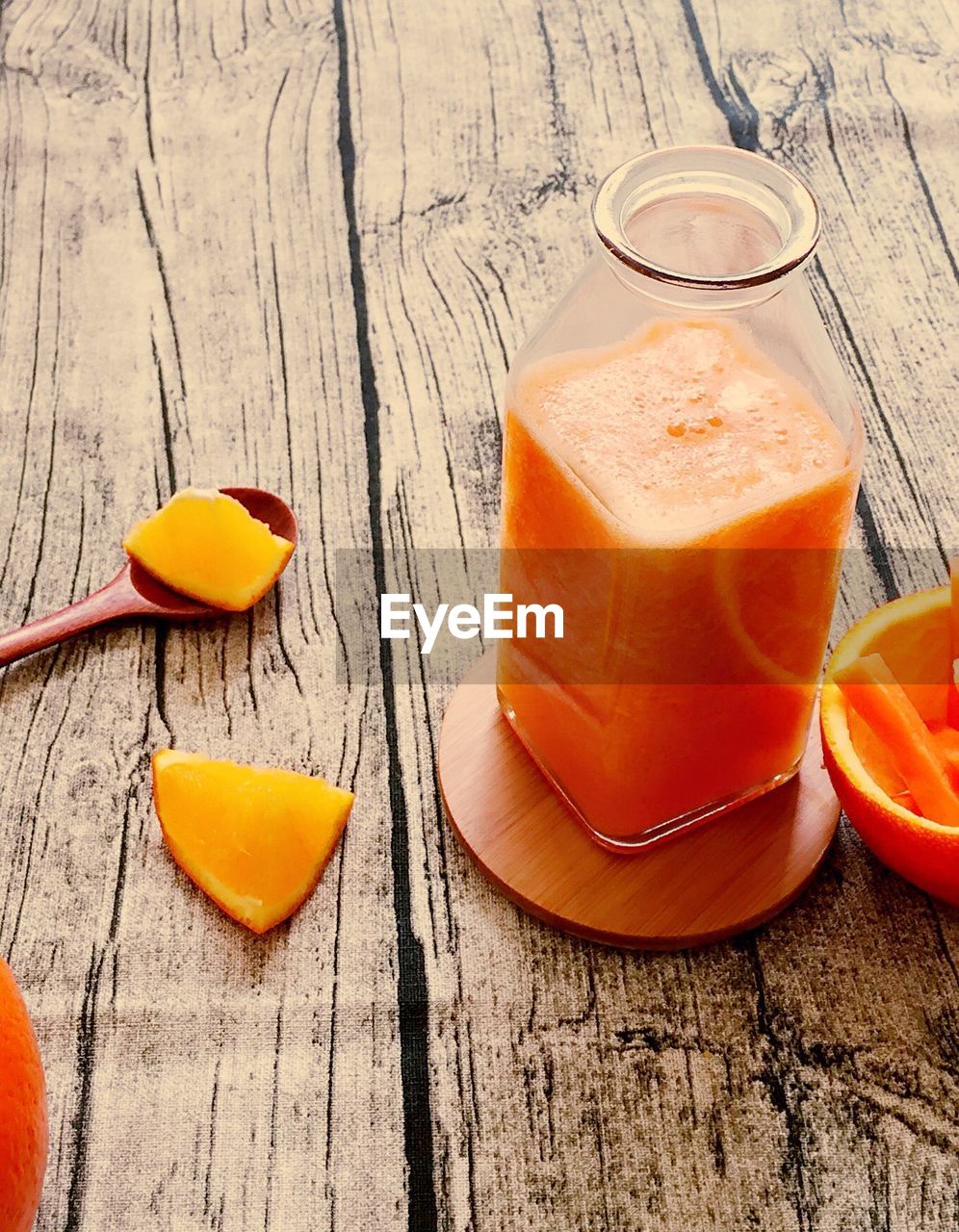 High angle view of orange juice in glass container on table