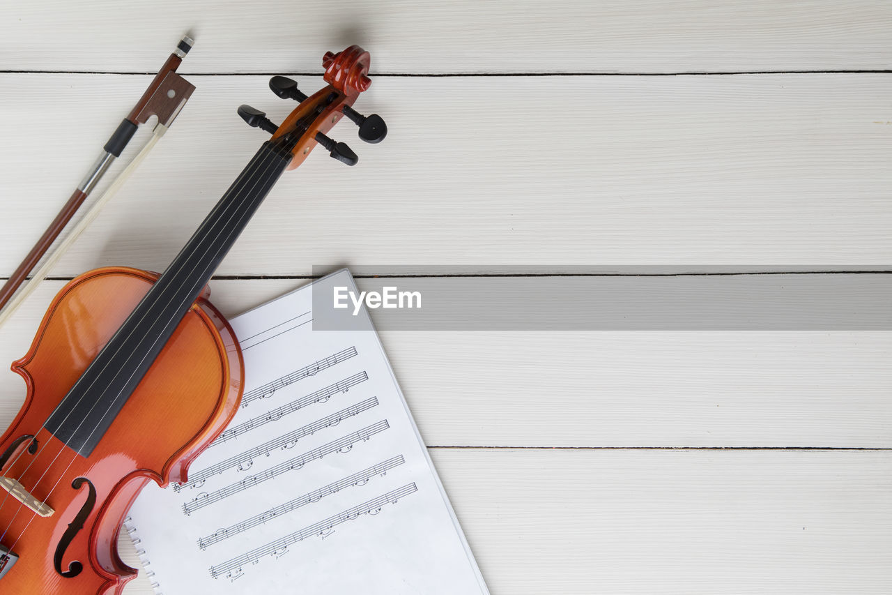 Directly above shot of violin and sheet music on table