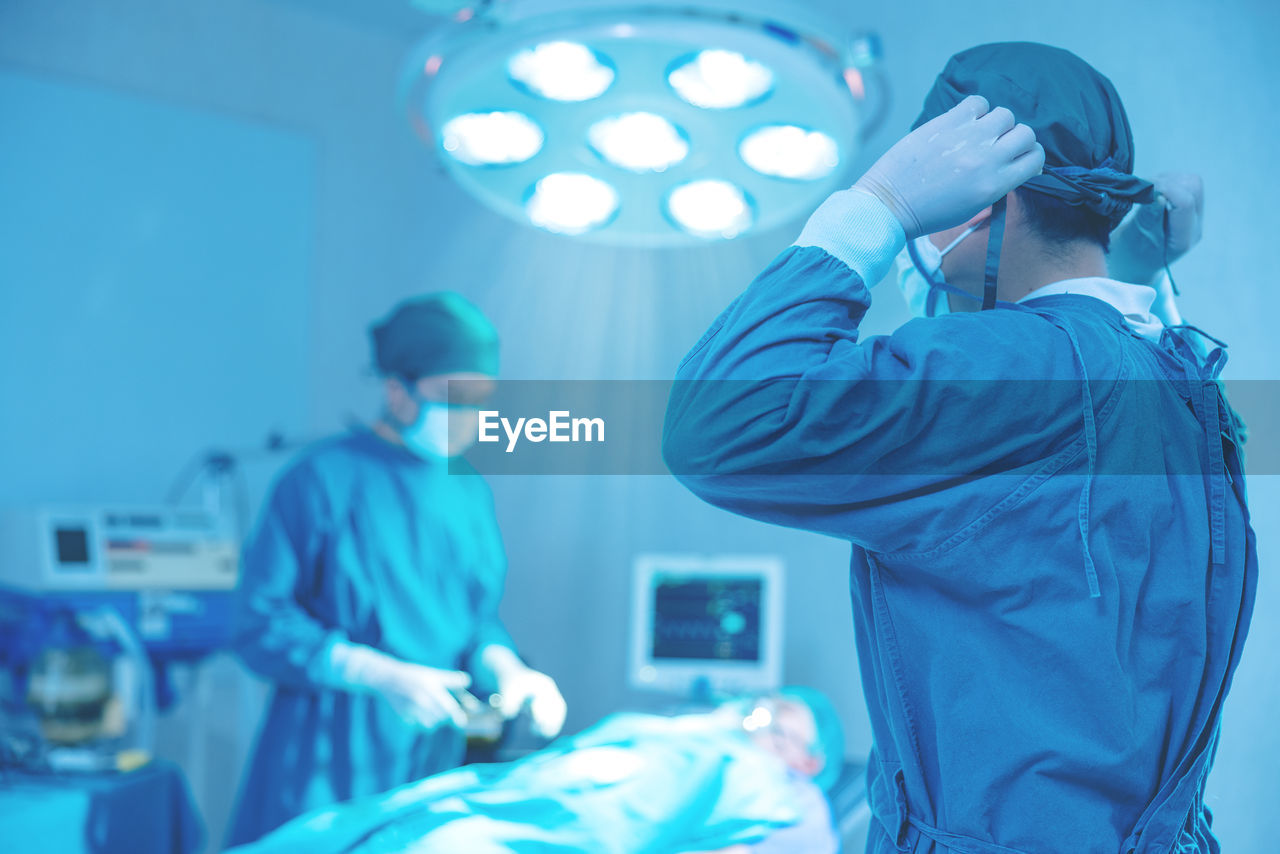 In the operating room of a hospital, a group of surgeons are performing surgery.
