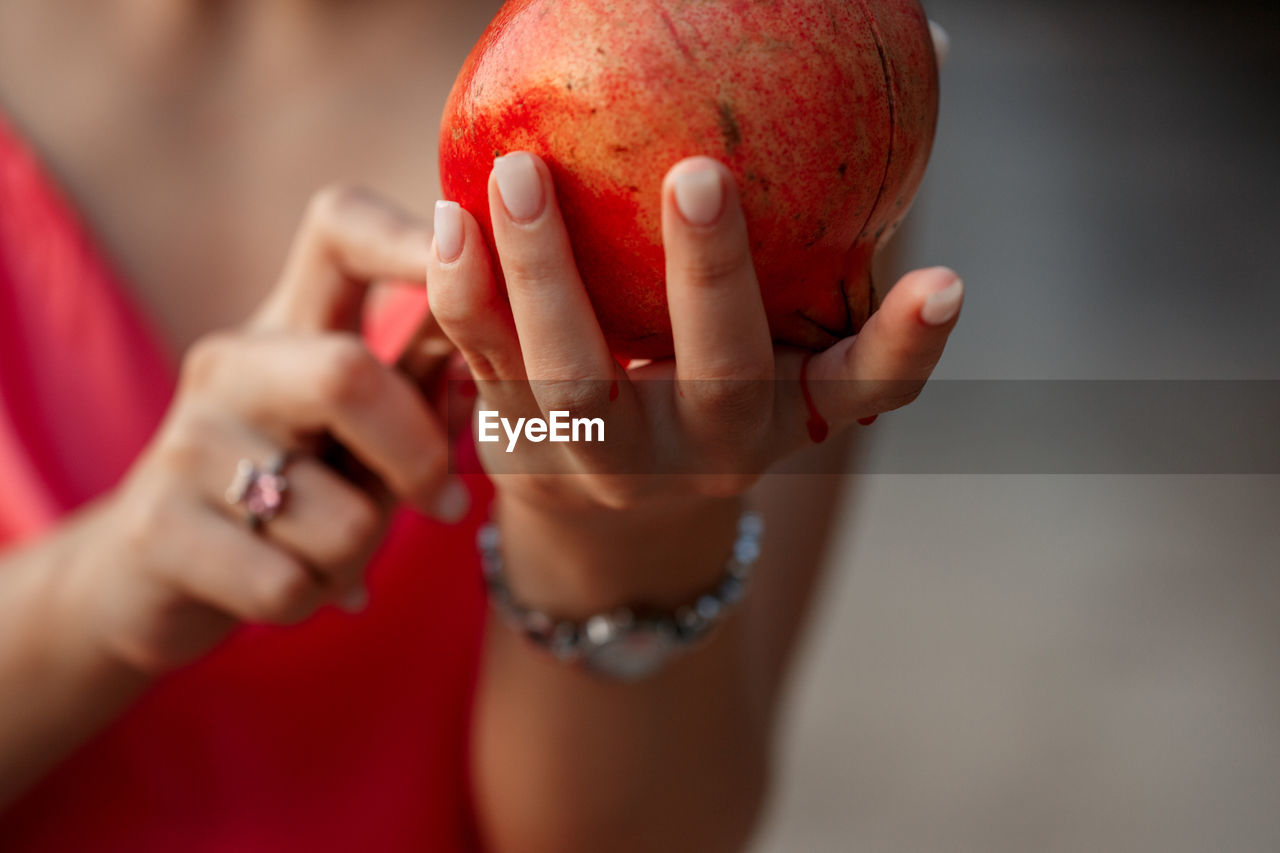 Pomegranate in the hands of a young woman. close up. shallow dof. selective focus