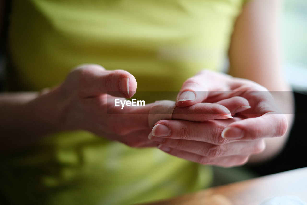 Midsection of woman with bandage on finger