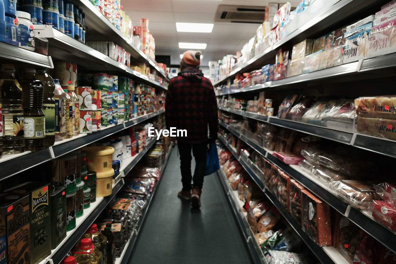 Rear view of man walking in supermarket