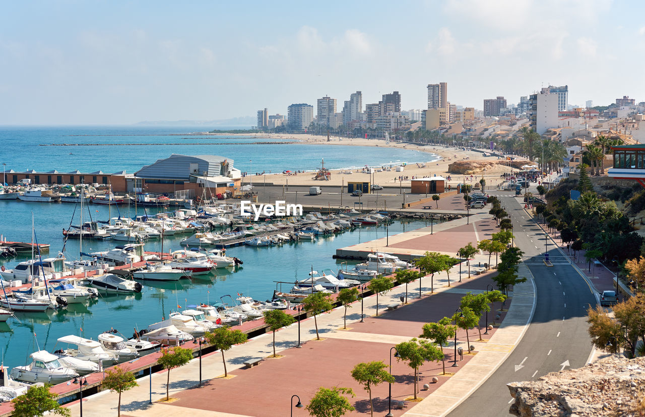 High angle view of sailboats moored at harbor in city