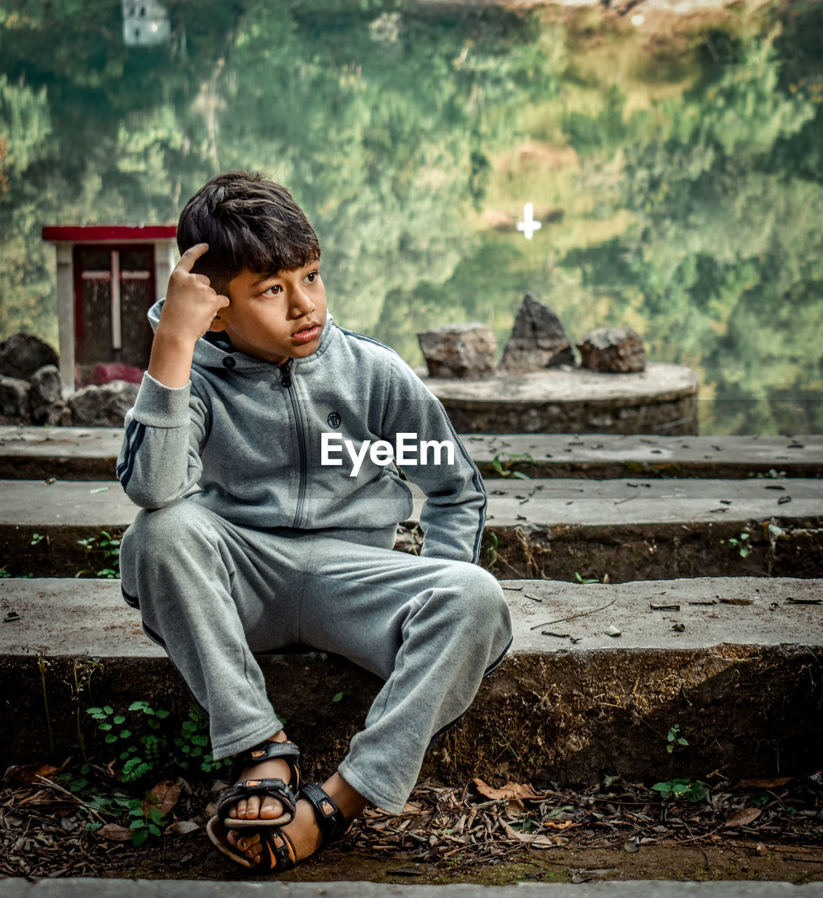 Boy looking away while sitting on staircase