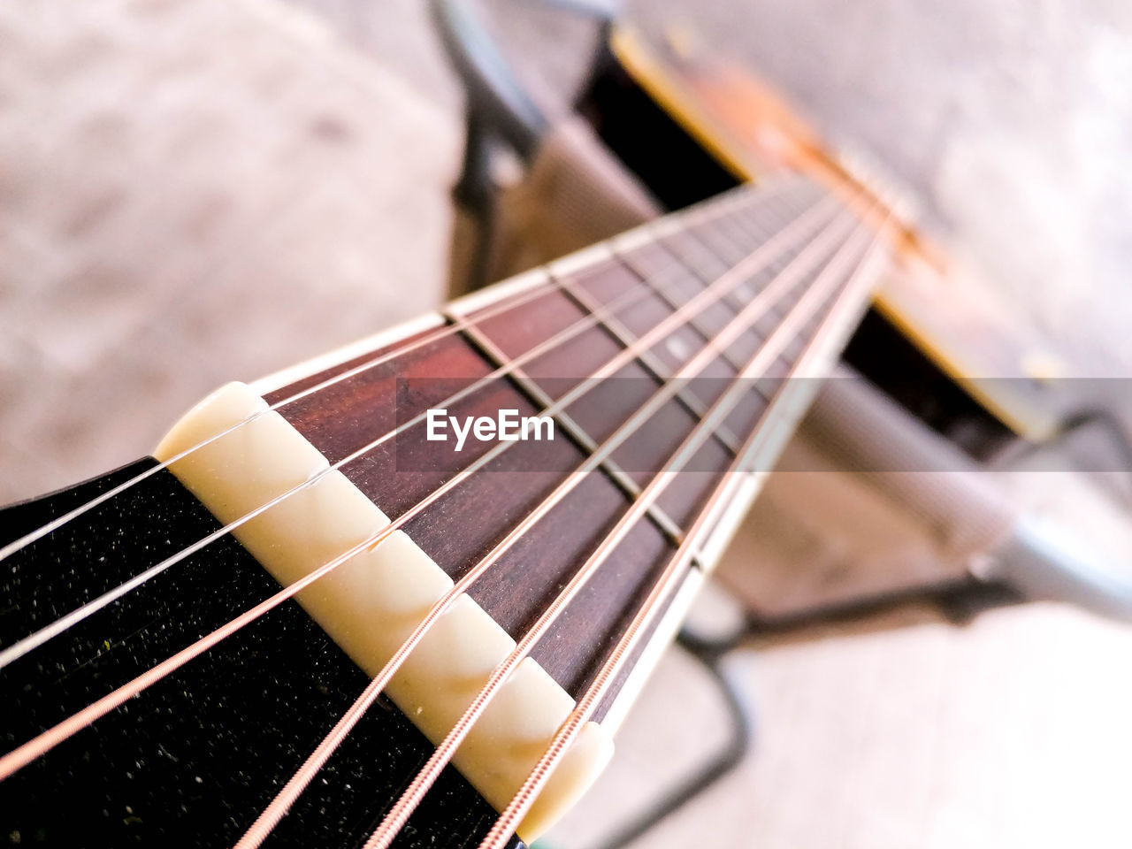 HIGH ANGLE VIEW OF GUITAR ON TABLE AT HOME