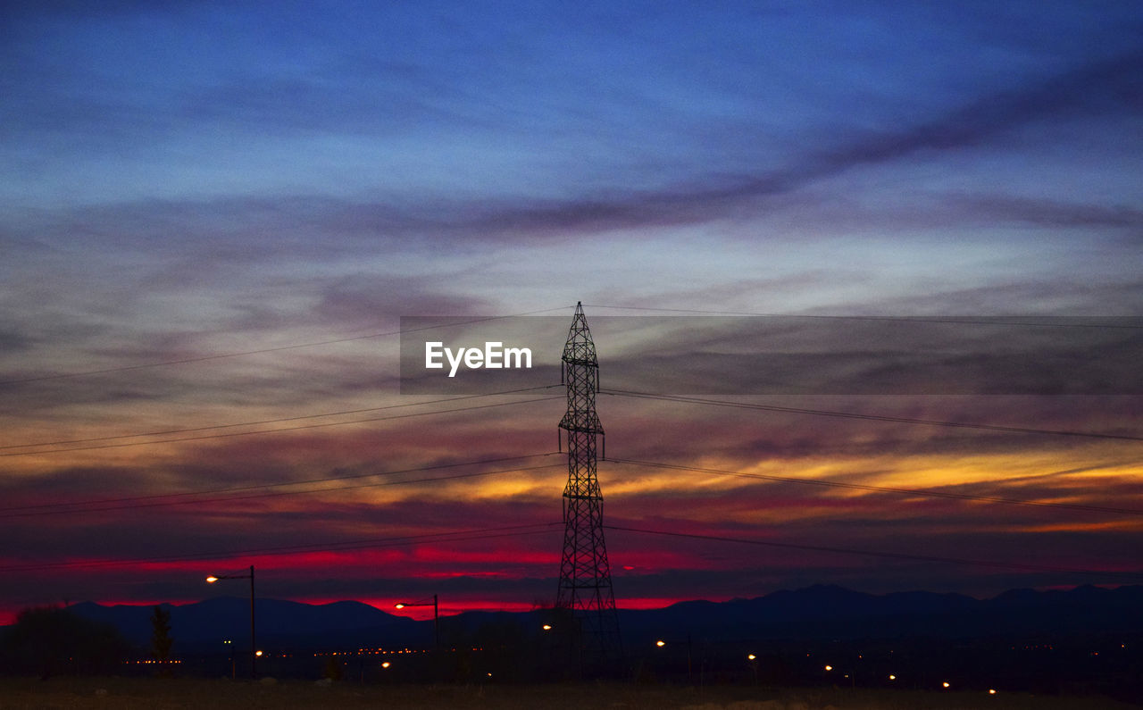 Silhouette electricity pylon against sky during sunset