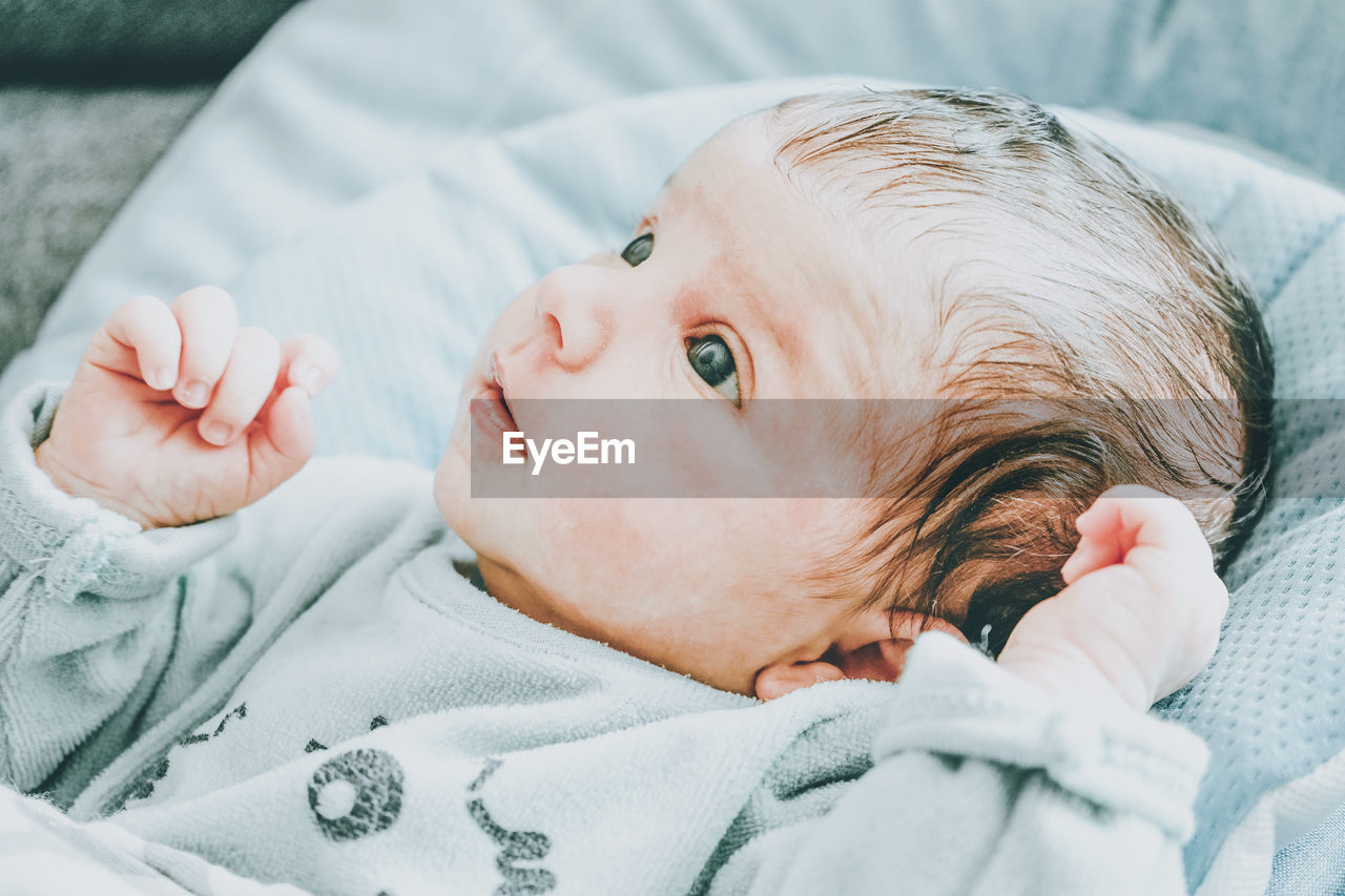 Portrait of cute baby lying on bed