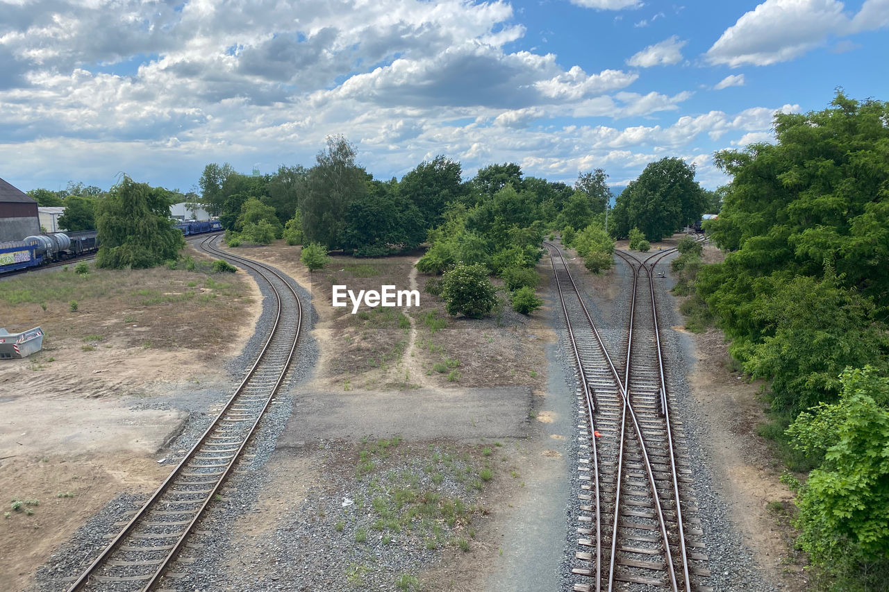 transportation, track, rail transportation, railroad track, transport, tree, sky, plant, cloud, railway, mode of transportation, nature, vehicle, travel, no people, the way forward, public transportation, train, day, road, architecture, rolling stock, outdoors, high angle view, environment, landscape, vanishing point, land