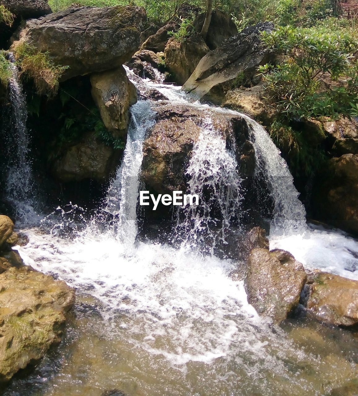 HIGH ANGLE VIEW OF WATERFALL ON ROCK