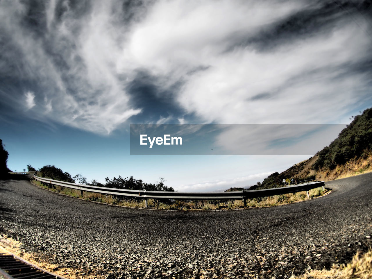 Scenic view of road by mountains against sky