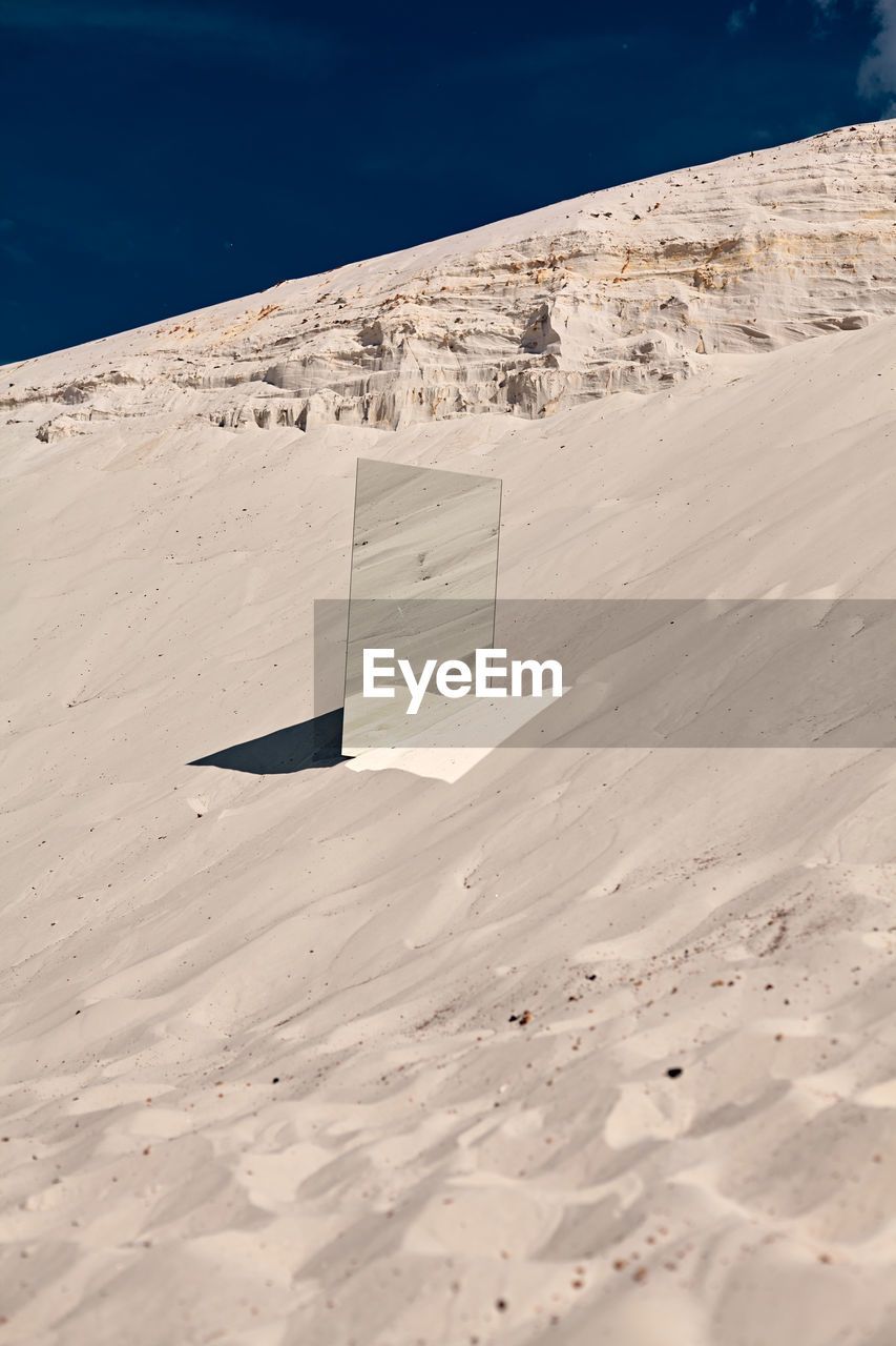 Shadow on sand at beach against sky mirror 