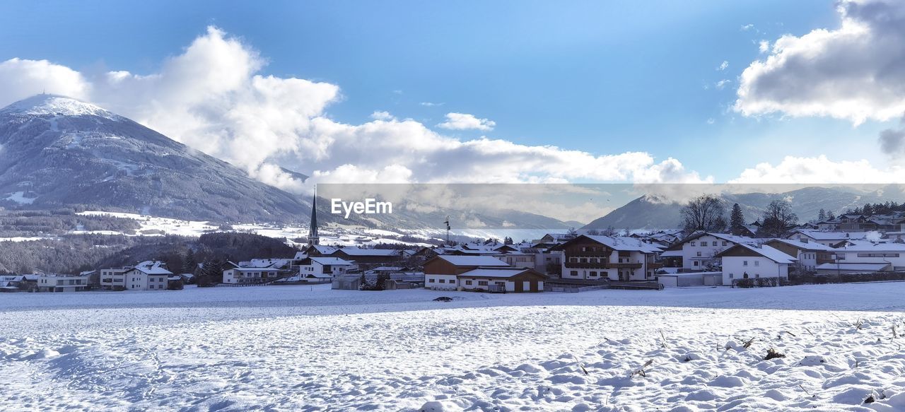 SCENIC VIEW OF SNOW COVERED HOUSES AGAINST SKY