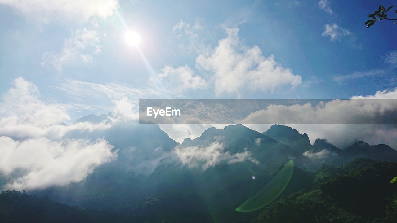 SCENIC VIEW OF MOUNTAINS AGAINST BRIGHT SUN