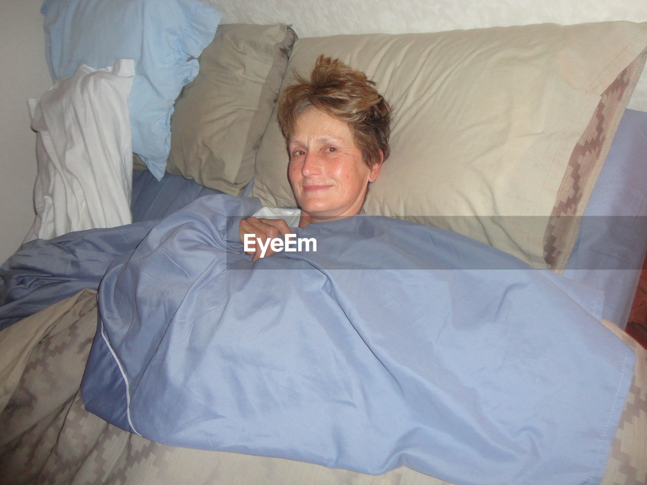 PORTRAIT OF YOUNG MAN LYING ON BED