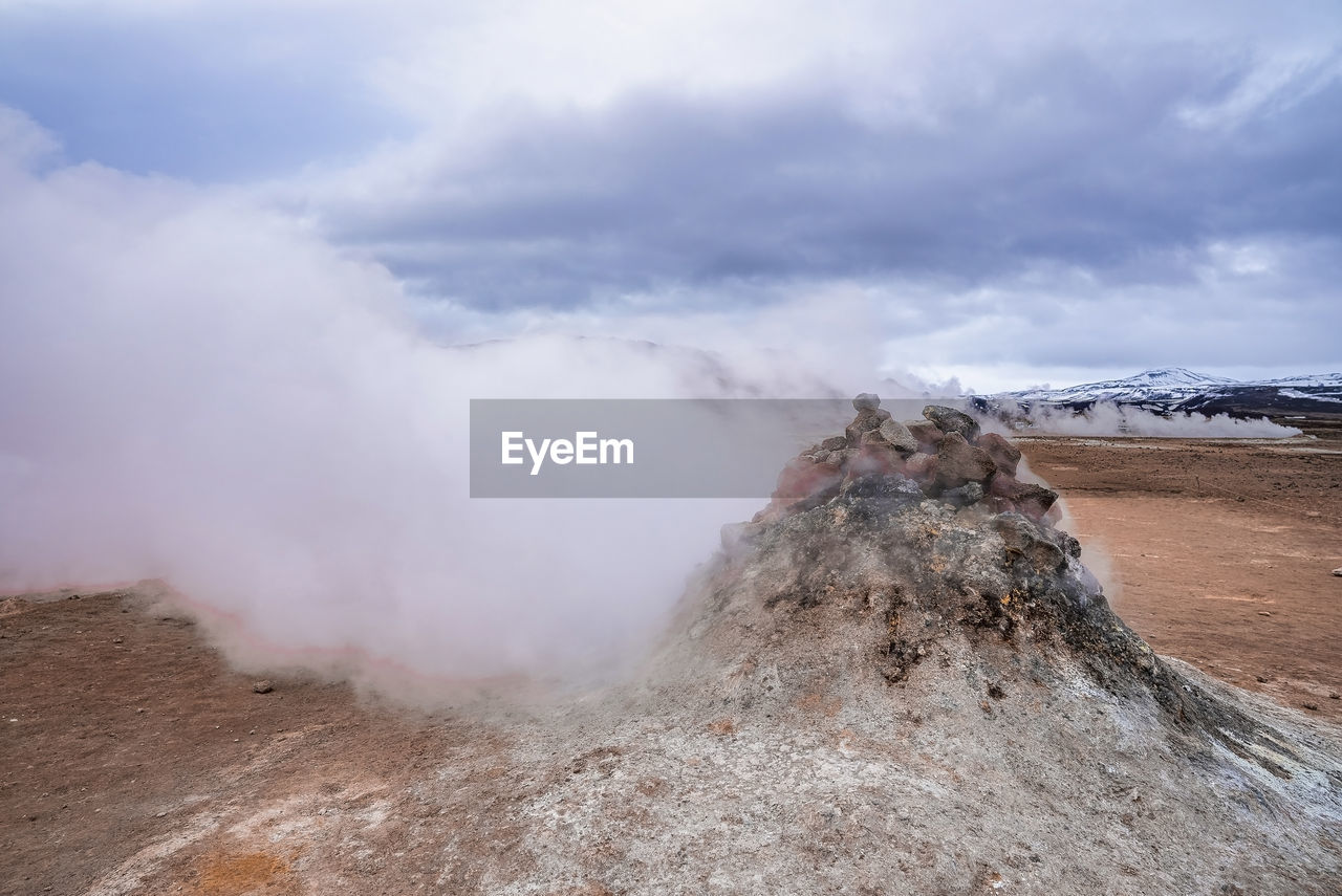 View of steaming fumarole in geothermal area of hverir at namafjall against sky