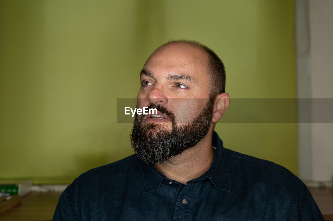 Man looks thoughtfully past the camera into the distance