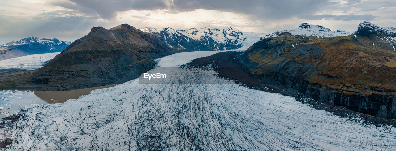 Beautiful glaciers flow through the mountains in iceland.