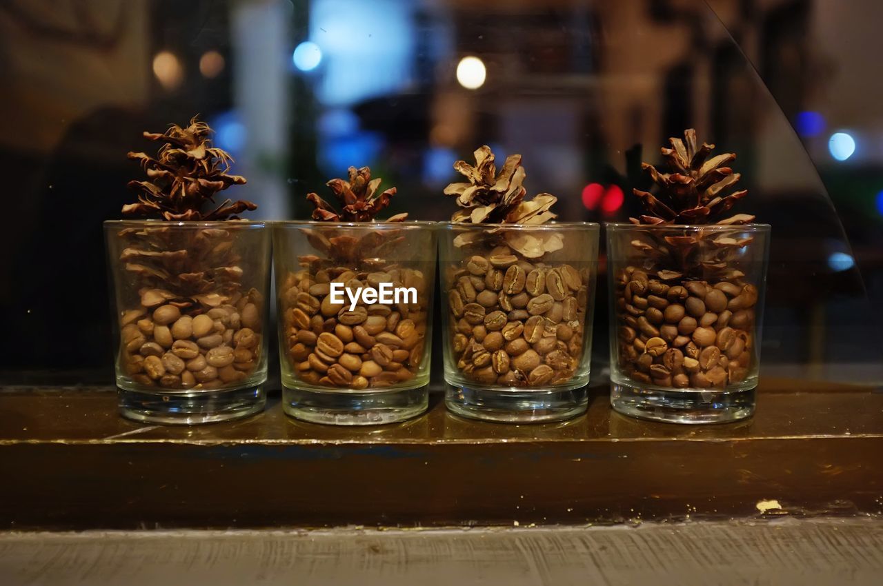 Close-up of roasted coffee bean in glass on table