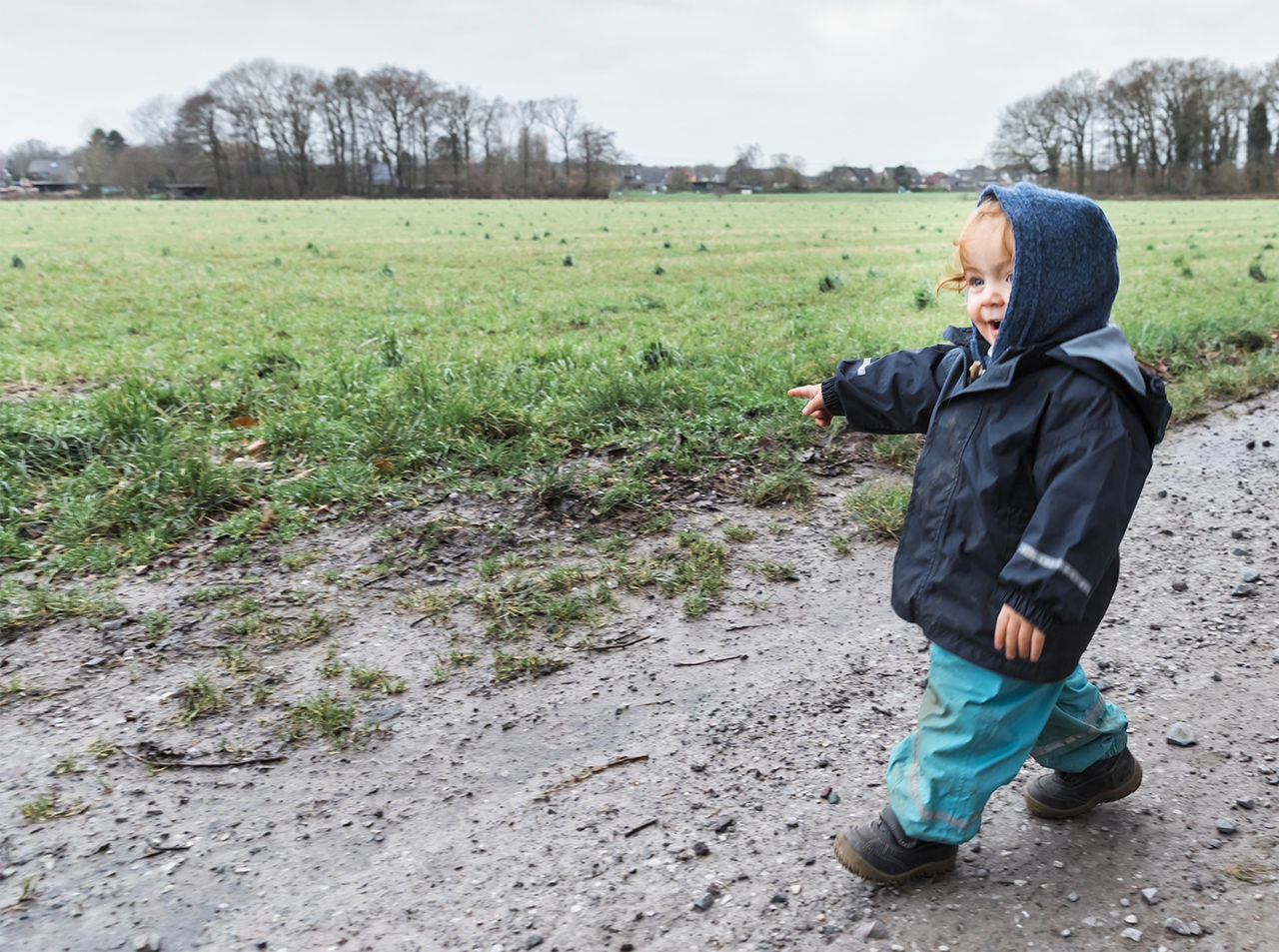 Full length of cute baby girl wearing warm clothing walking on field