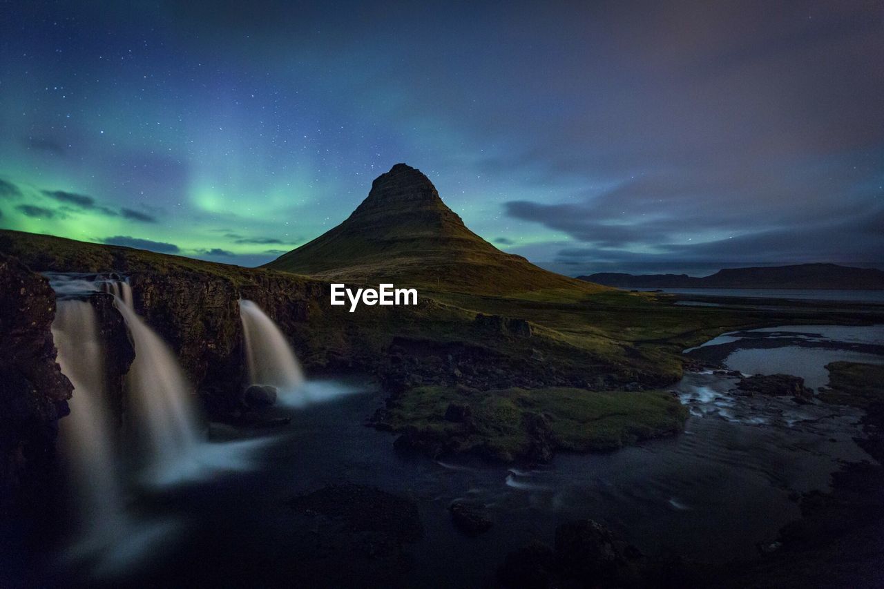 Scenic view of majestic mountains against sky at night