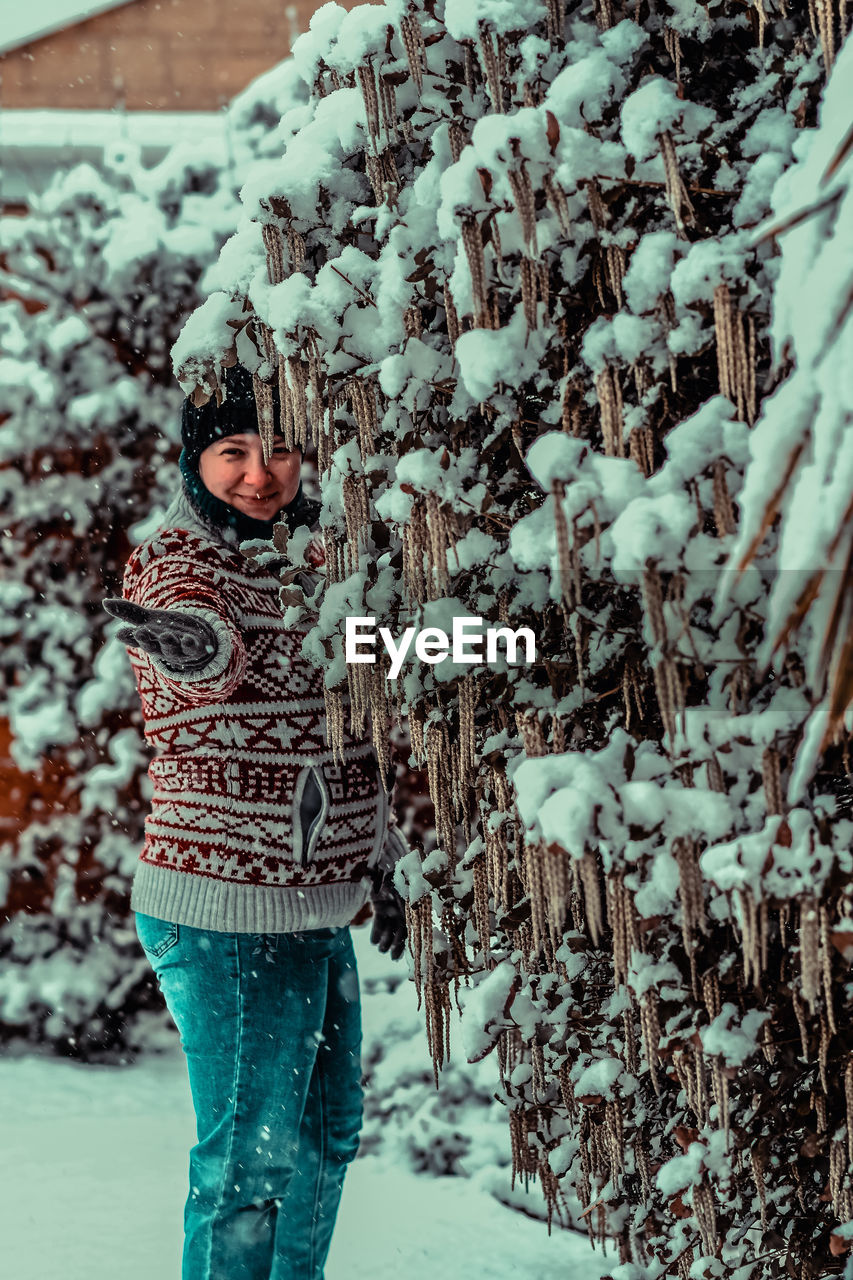 Woman standing on snow covered tree