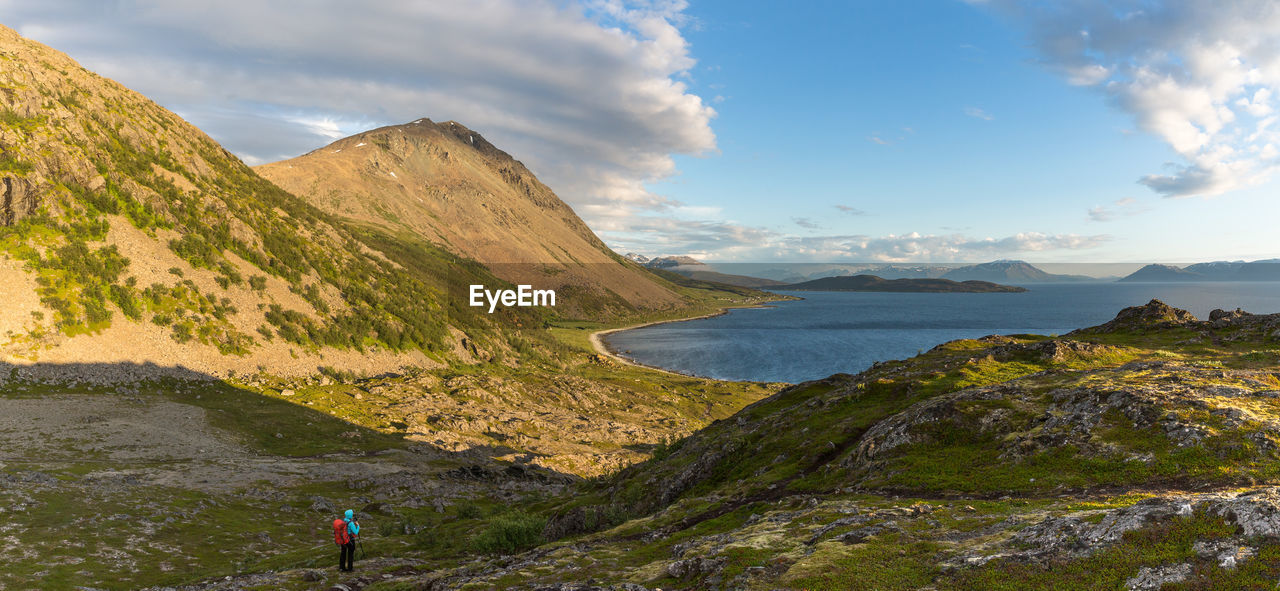 Hiker on mountain against sky at lyngseidet