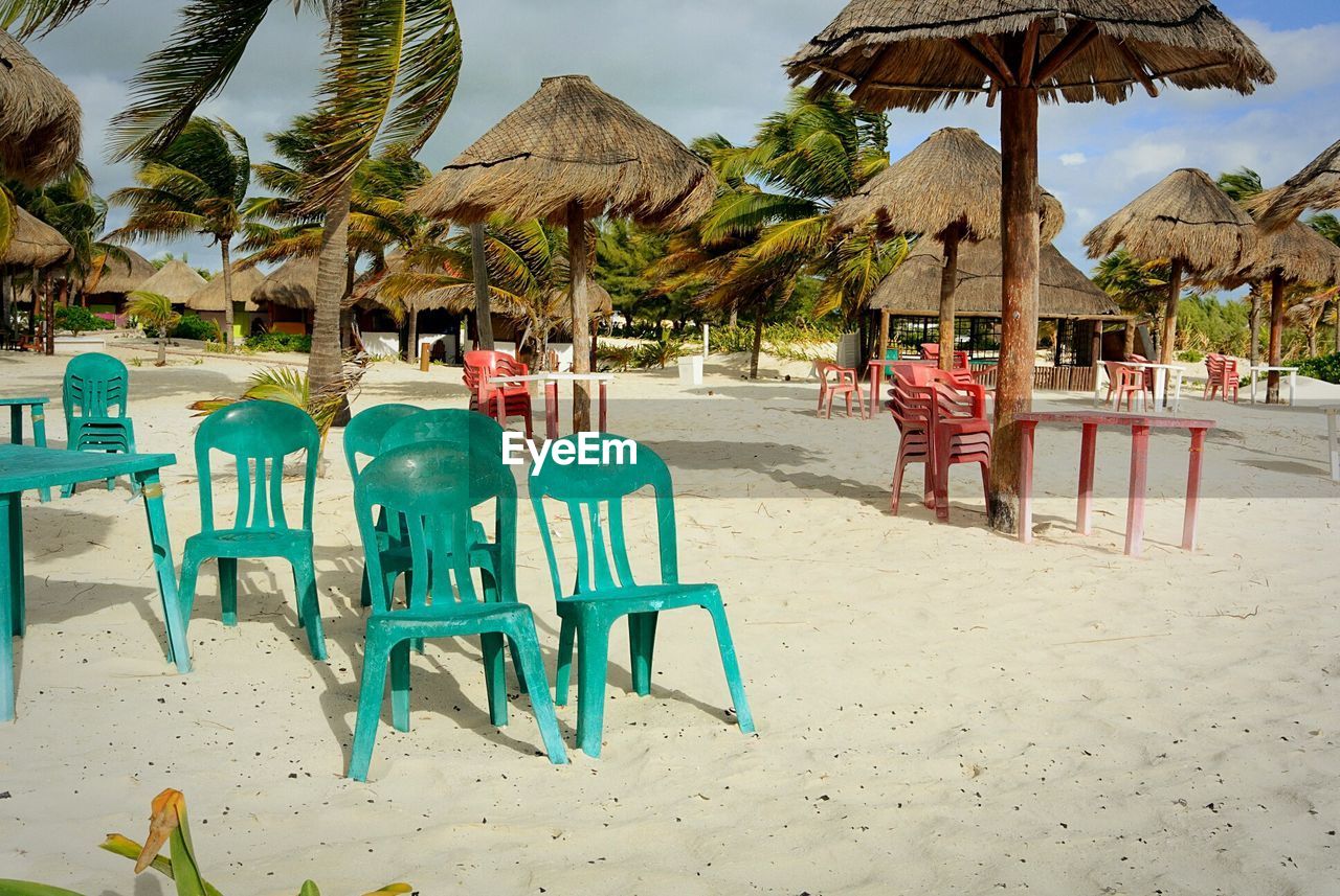 Empty chairs at sandy beach