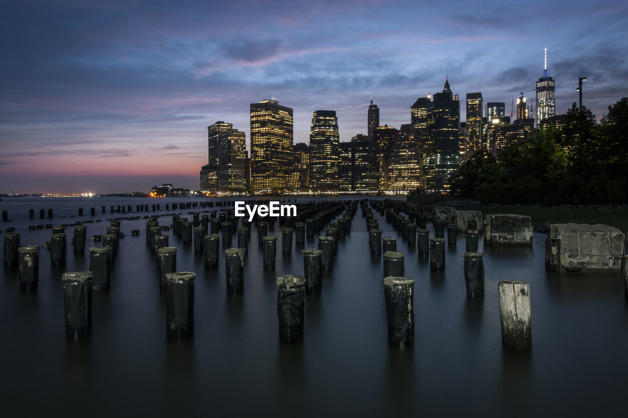 Panoramic view of river and buildings against sky during sunset