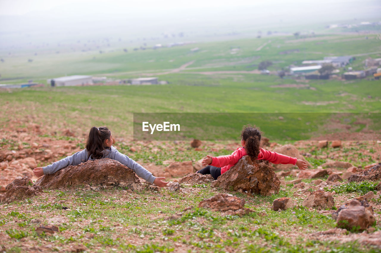 WOMEN SITTING ON FIELD