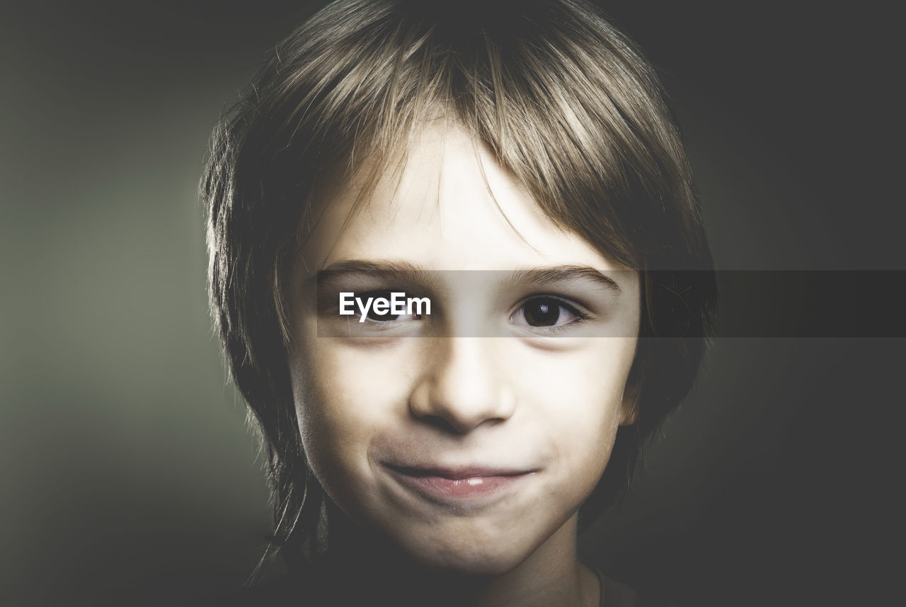 Close-up portrait of boy on gray background