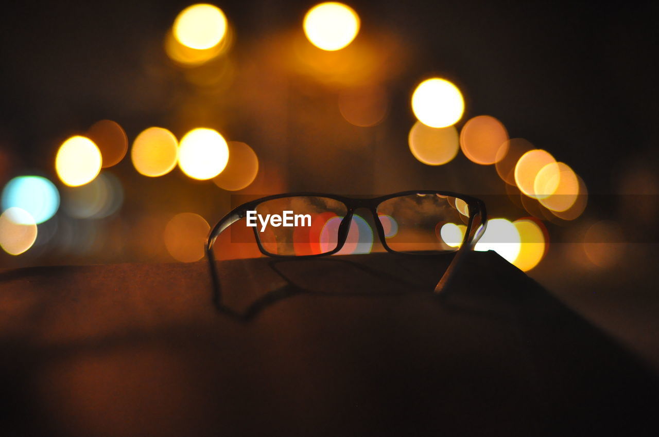 Close-up of sunglasses against illuminated background