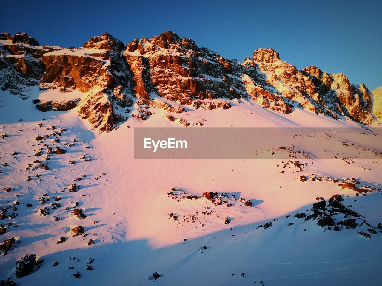 Scenic view of snowcapped mountains against clear sky