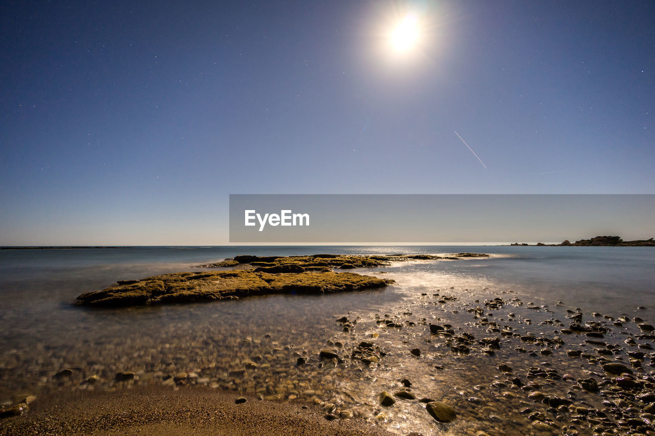 Scenic view of sea against clear sky at night