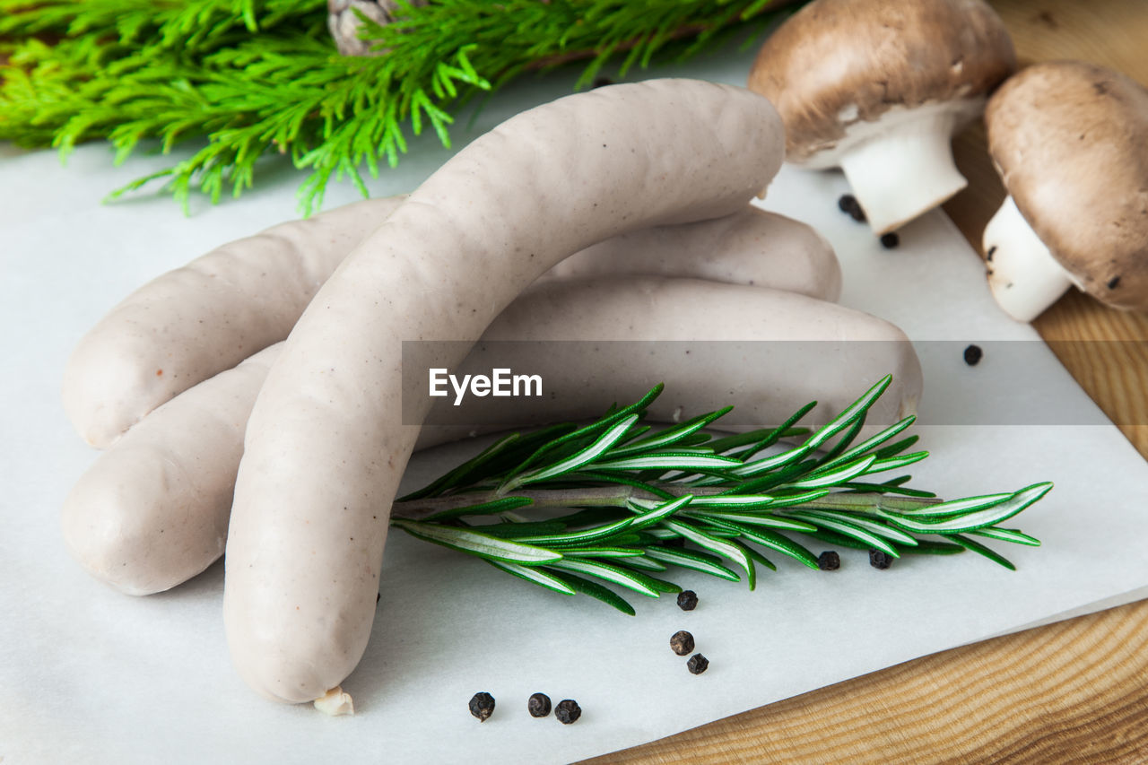 Close-up of sausage with mushroom and rosemary on table