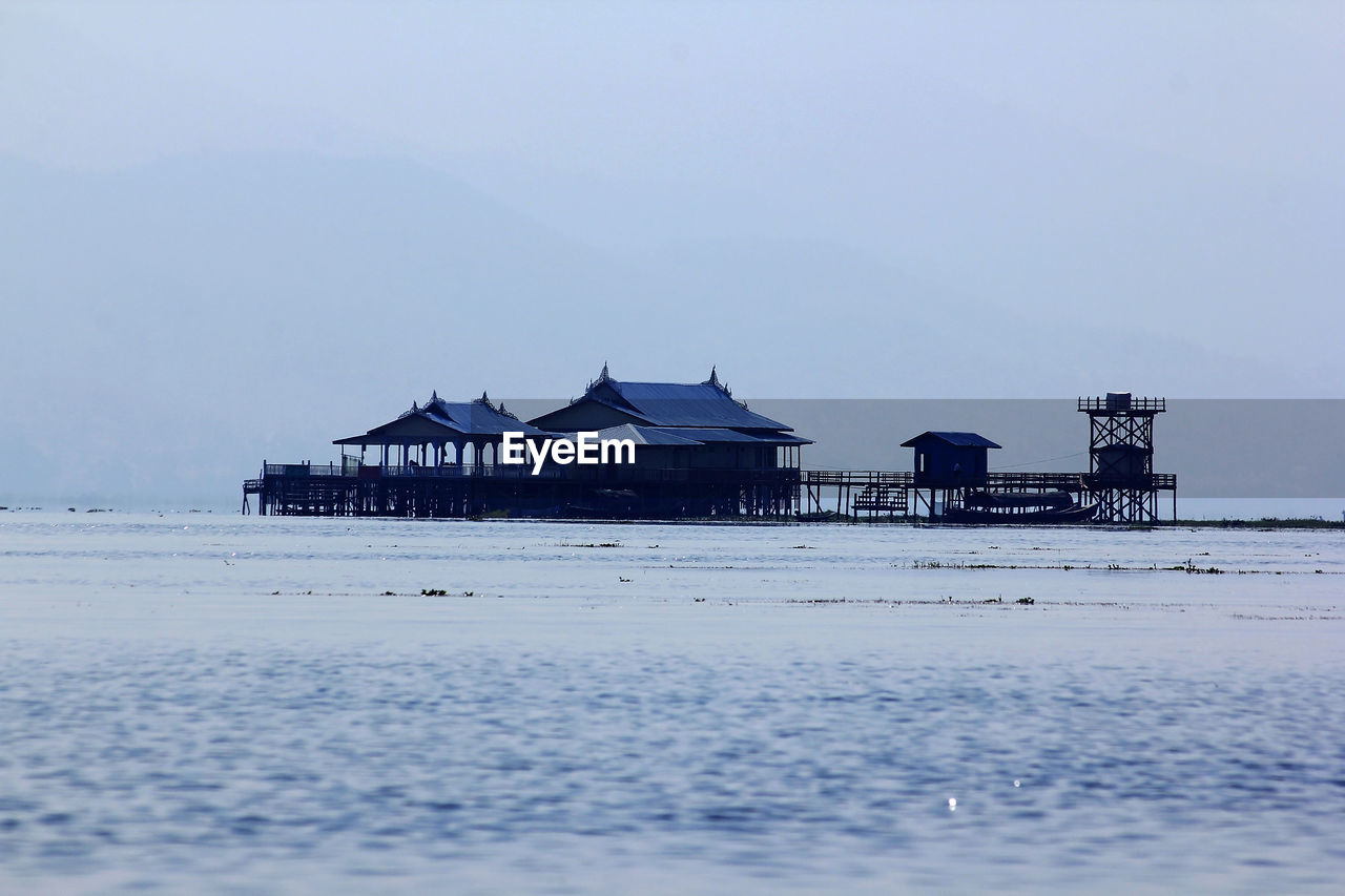 Built structure on beach by sea against sky