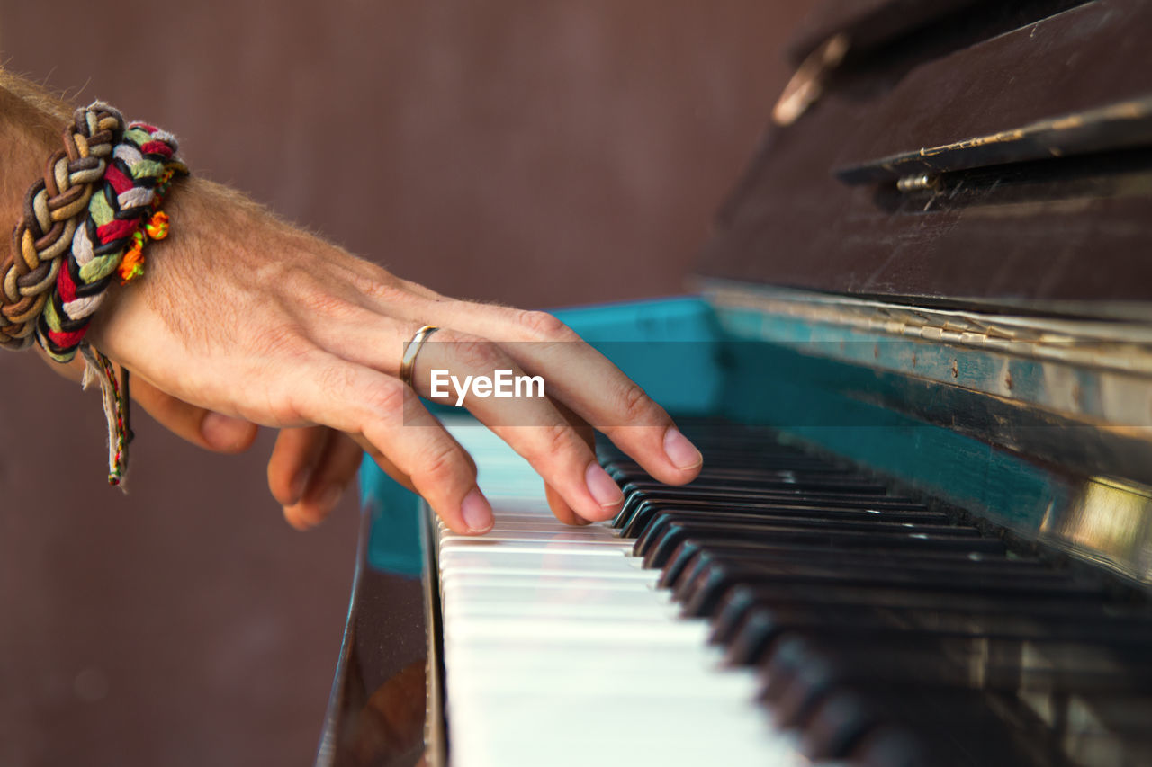 Close-up of man playing piano in home