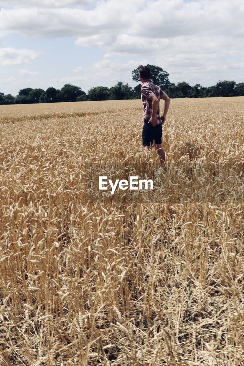 FULL LENGTH OF MAN STANDING IN FARM