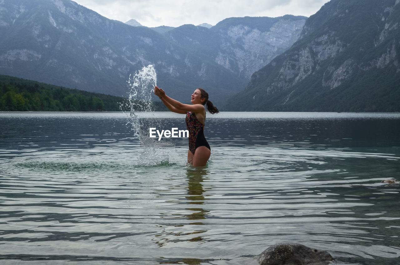 Teenage girl splashing water in lake