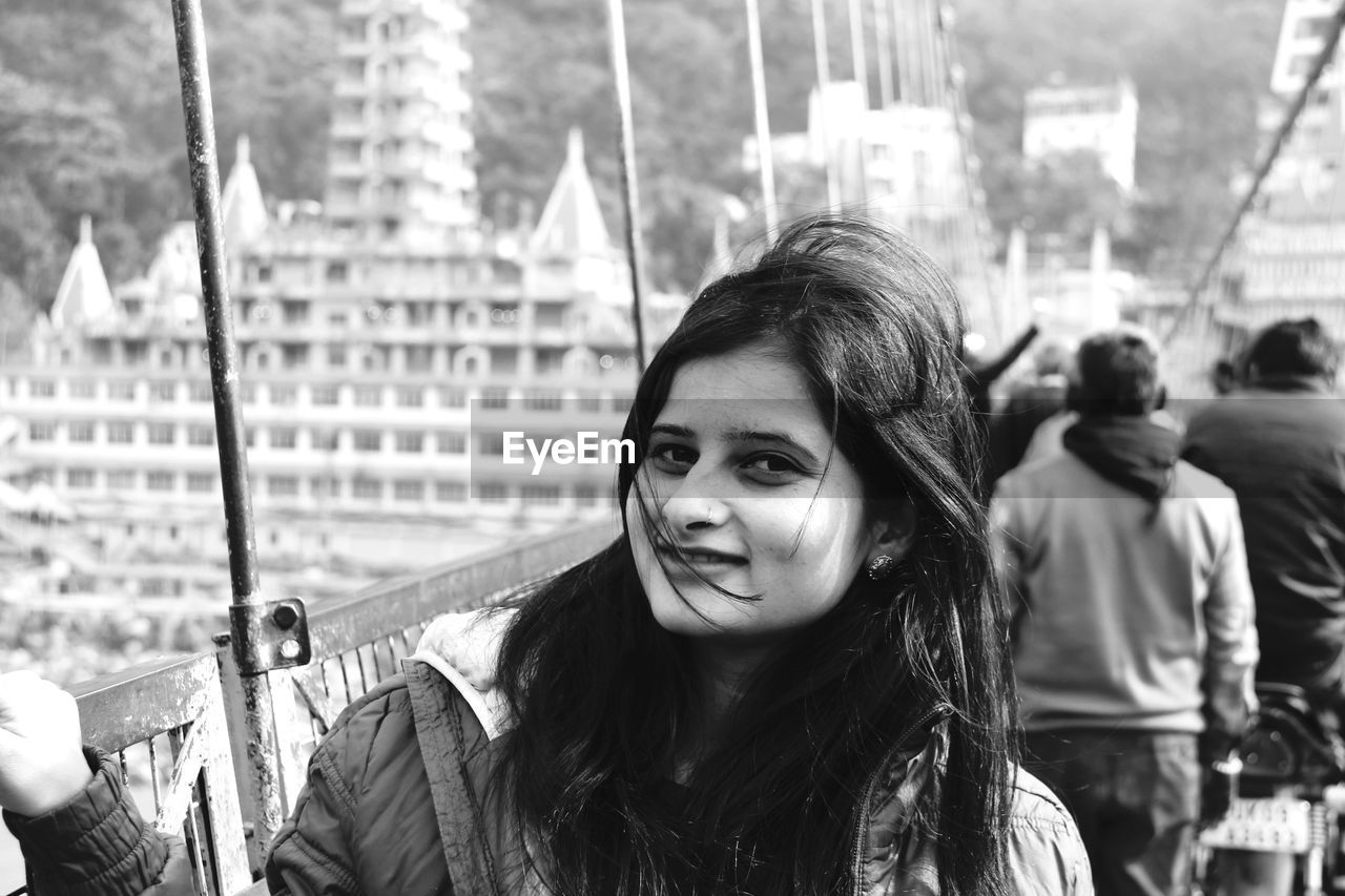 Portrait of smiling woman standing on bridge