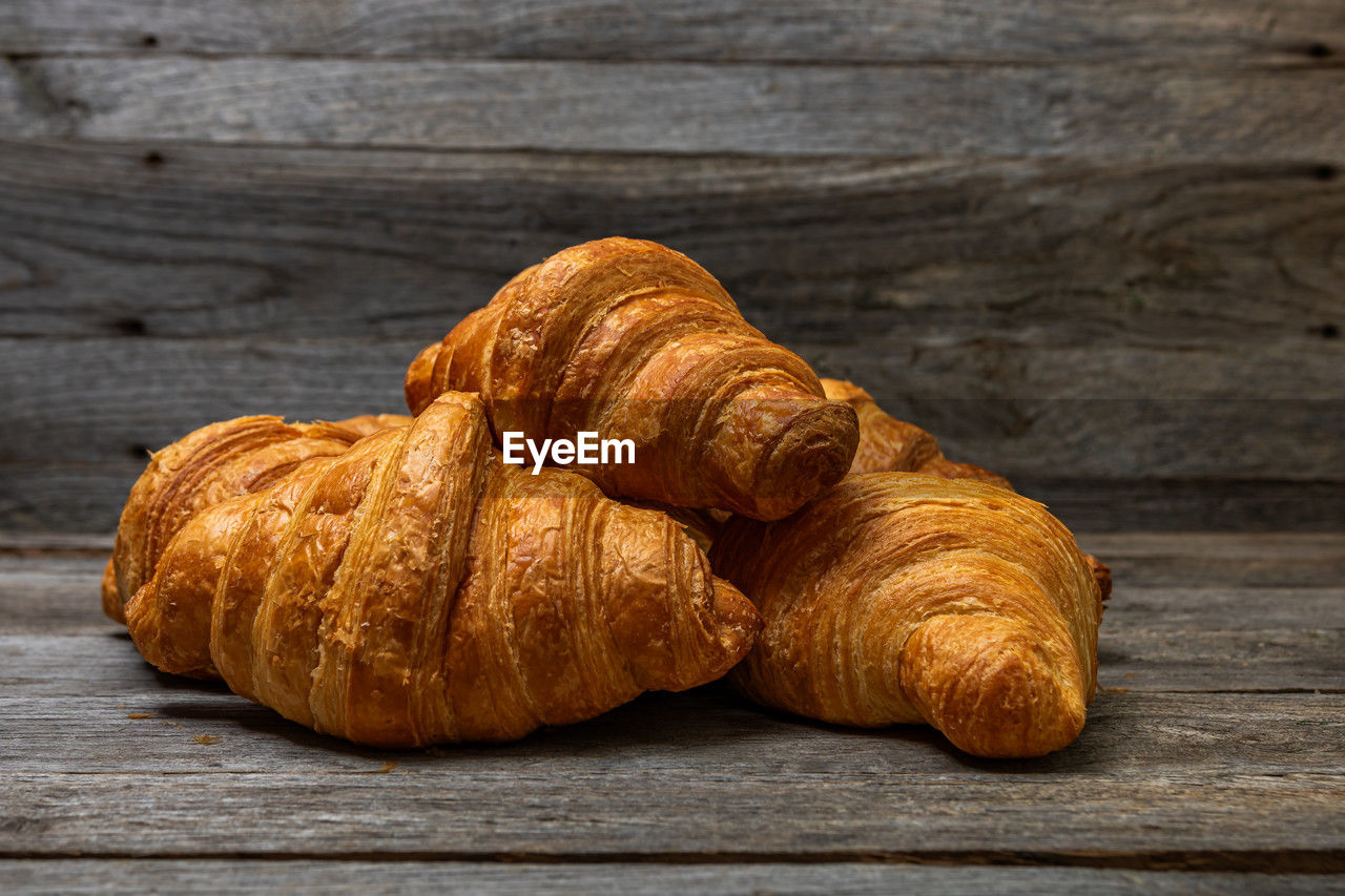 croissant, food and drink, food, viennoiserie, french food, freshness, baked, table, wood, still life, dessert, produce, no people, brown, indoors, close-up, bread, wellbeing, healthy eating, studio shot, pastry, rustic