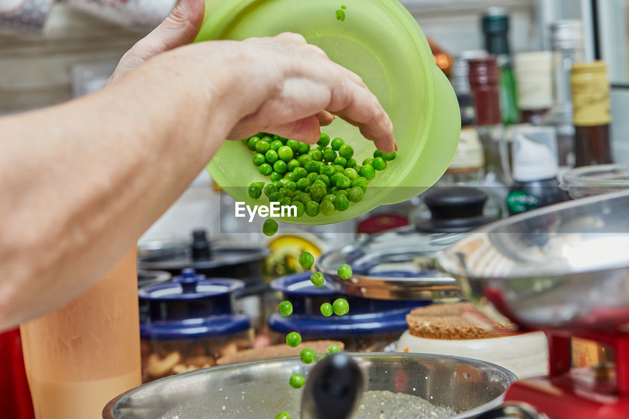 MIDSECTION OF MAN PREPARING FOOD AT HOME