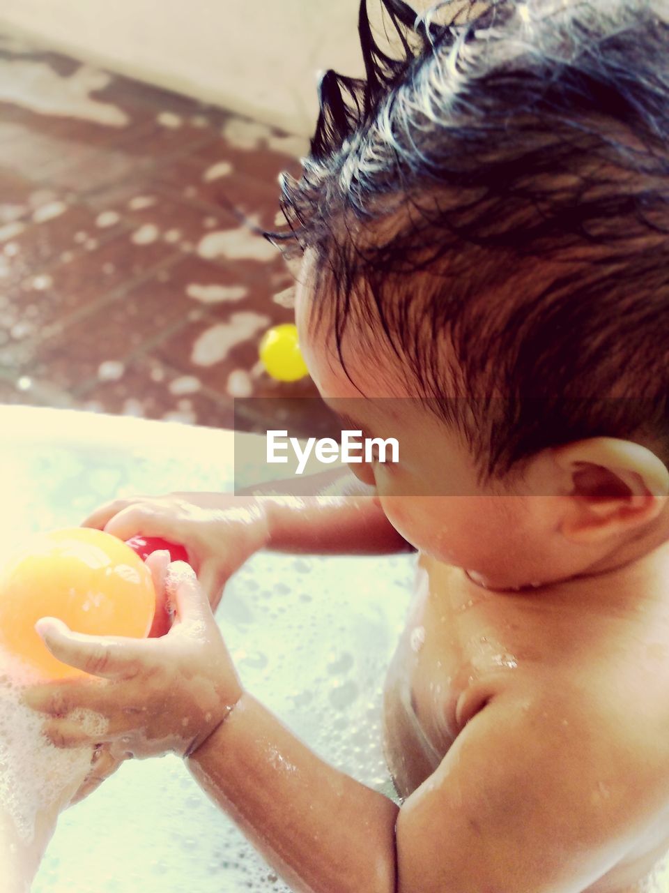 Close-up of shirtless baby boy having shower