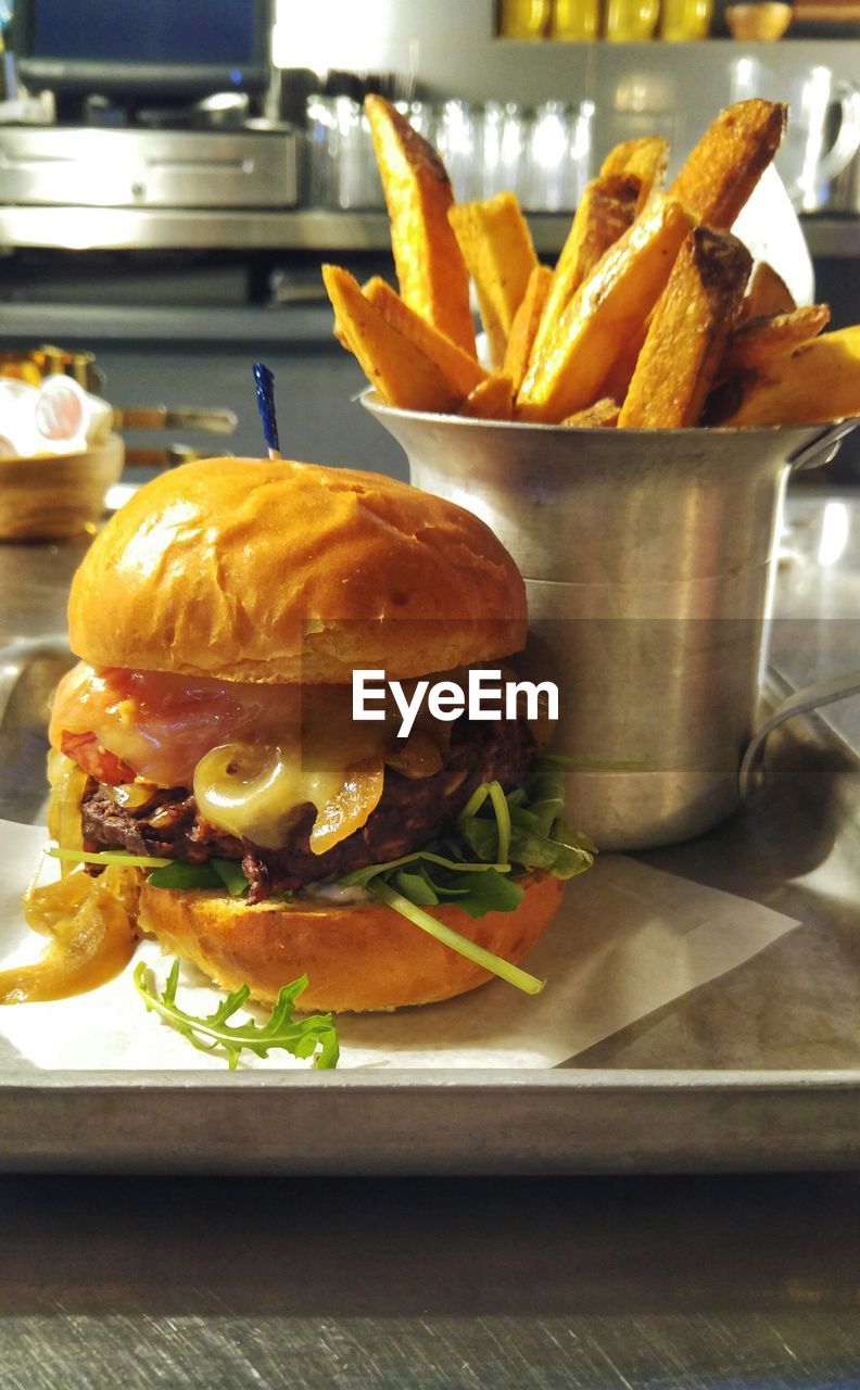 Burger by french fries in tray on table