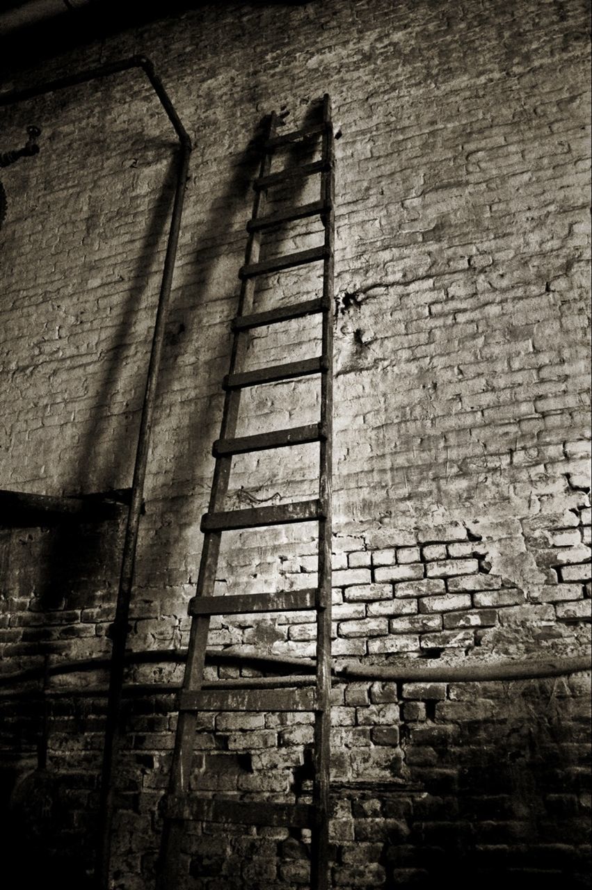 Ladder leaning against brick wall