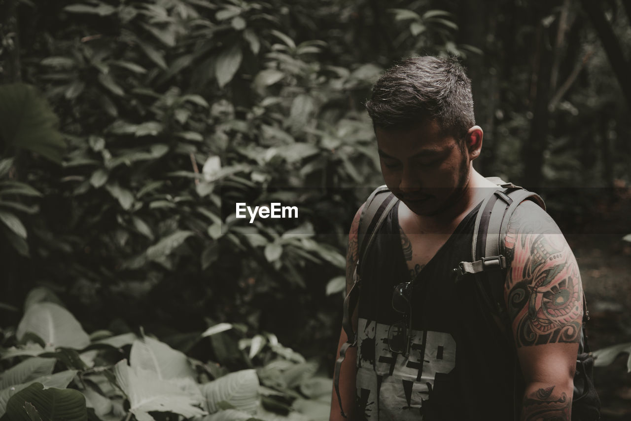 A view of a man looking down, inside the forest