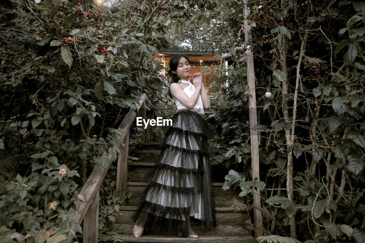 Rear view of woman standing amidst plants