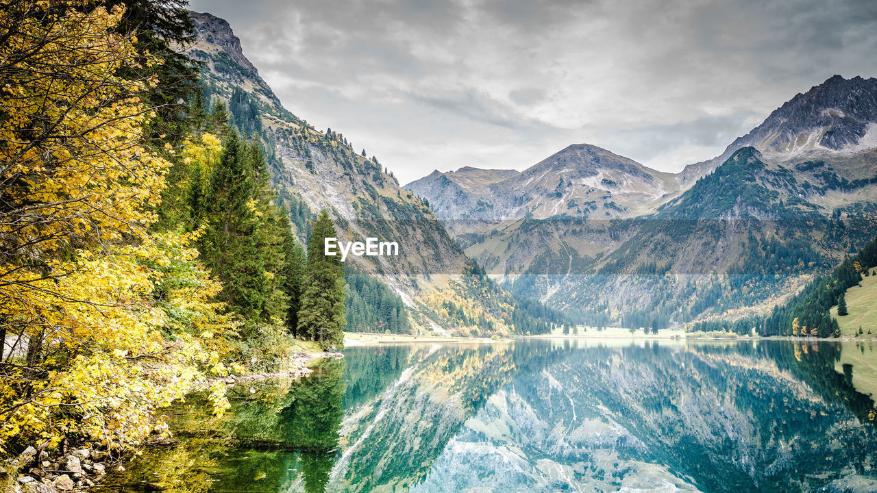 Scenic view of lake by mountains against sky