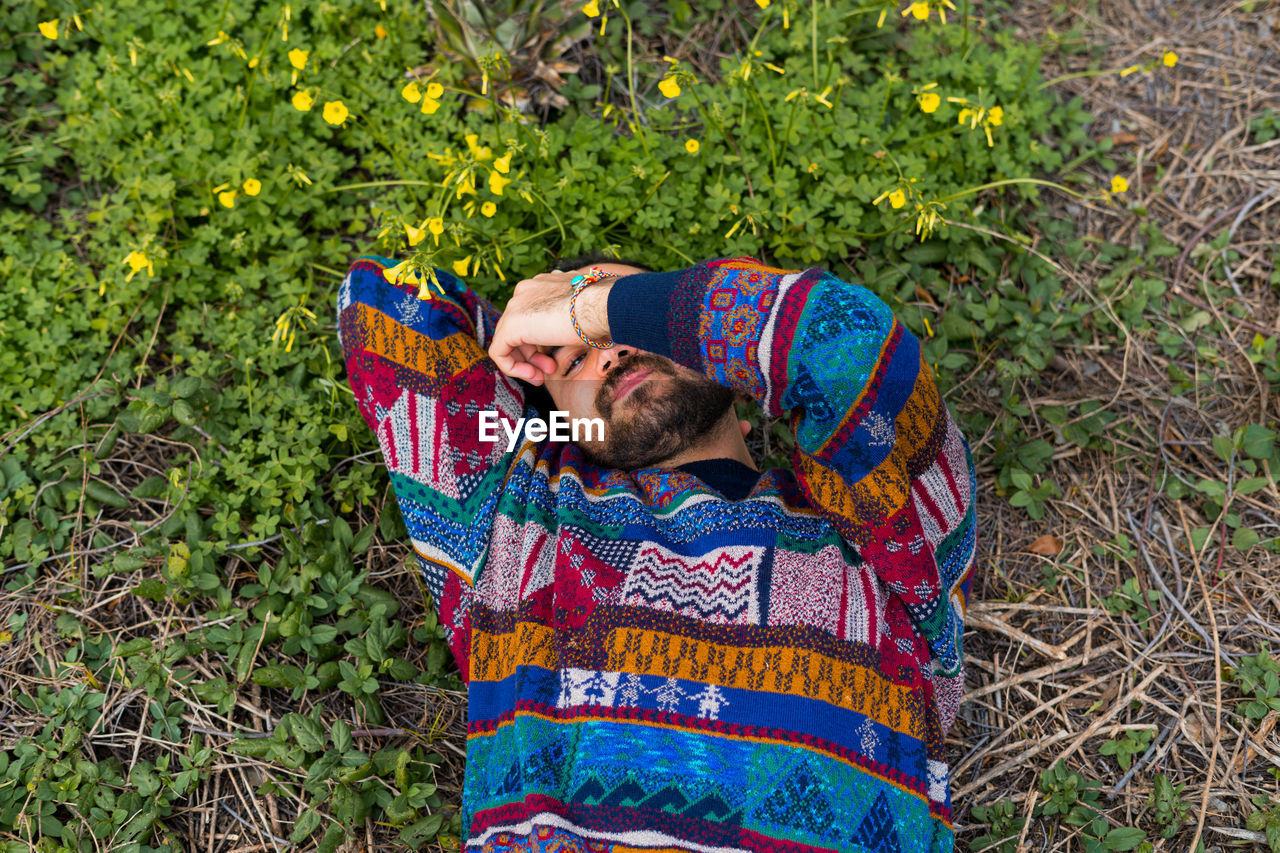 Moroccan man laying on the ground with his hand over his face